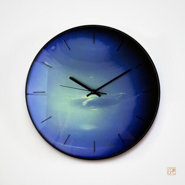 Neptune glass wall clock in deep blue and icy turquoise tones, with black hands, slim black hour markers and a dark edge on a light background.